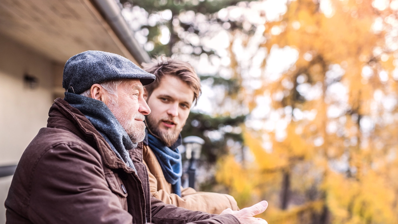 Vater und Sohn genießen zusammen den schönen Herbsttag auf dem Balkon
