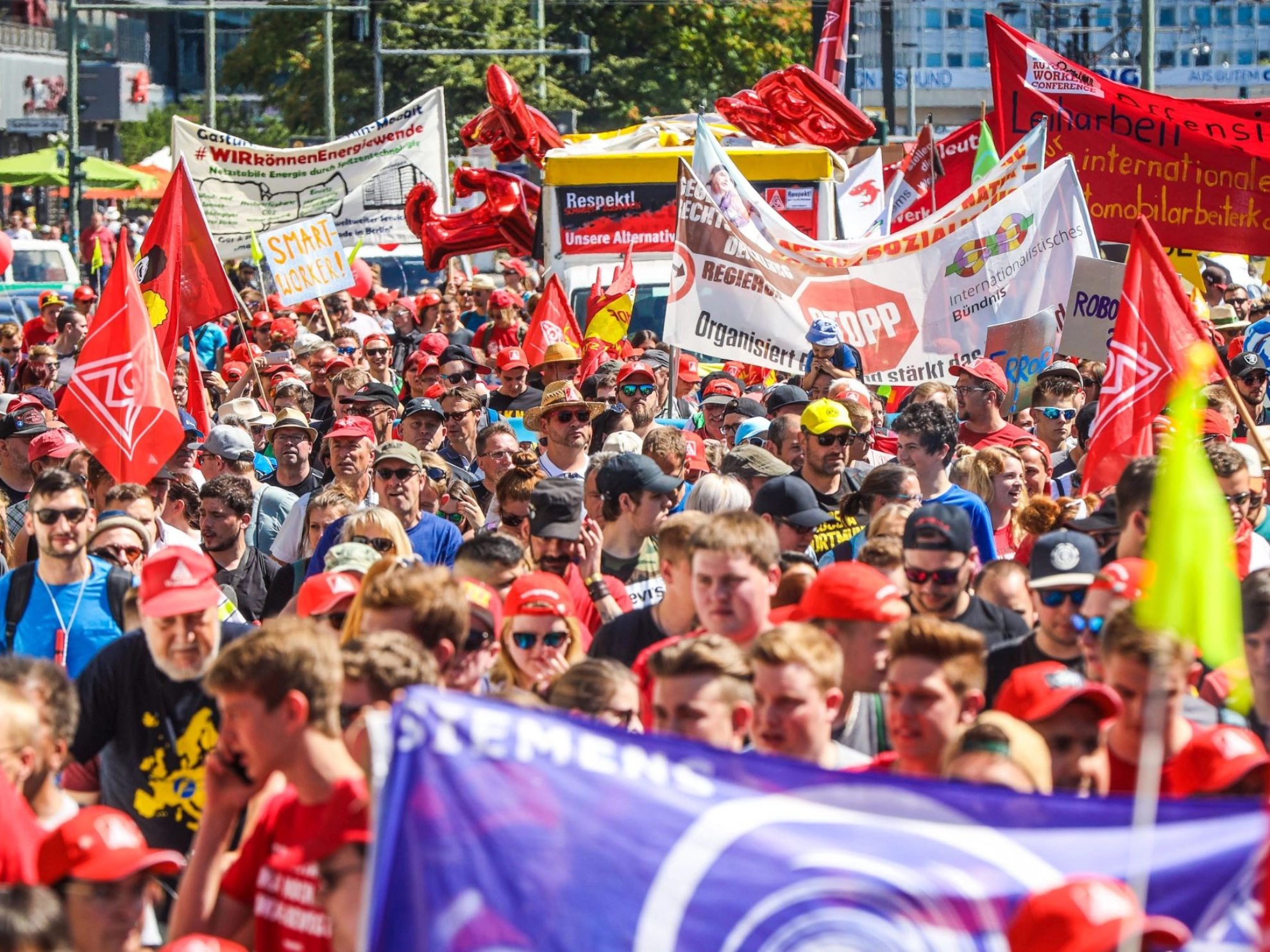 Metallerinnen und Metaller demonstrieren auf der FairWandel-Kundgebung mit verschiedenen Bannern