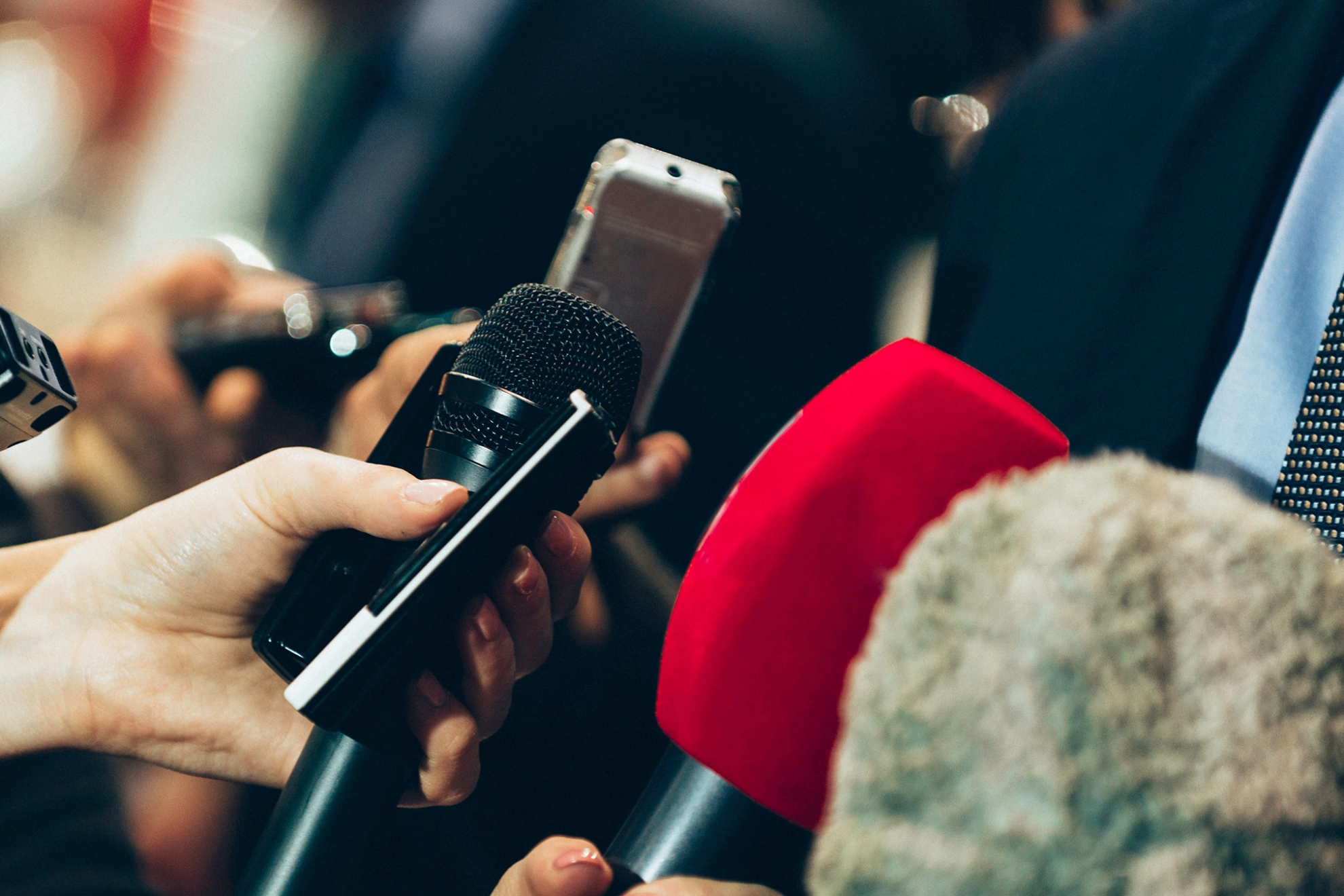 Mann wird bei einem Pressetermin interviewt